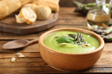 Delicious asparagus soup served on wooden table