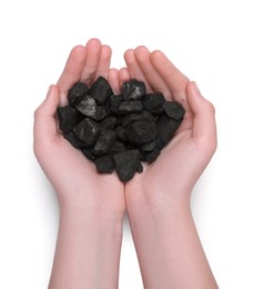 Woman with handful of coal on white background, top view