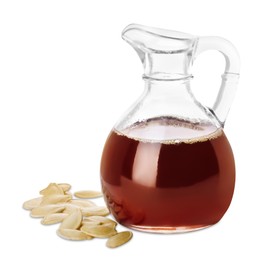 Photo of Fresh pumpkin seed oil in glass jug and kernels isolated on white