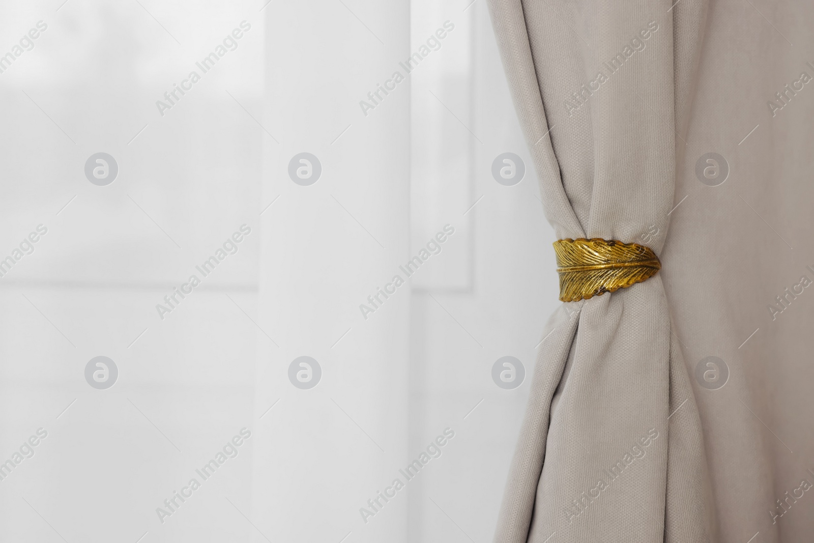 Photo of Light grey window curtains with elegant holder and white tulle. Space for text