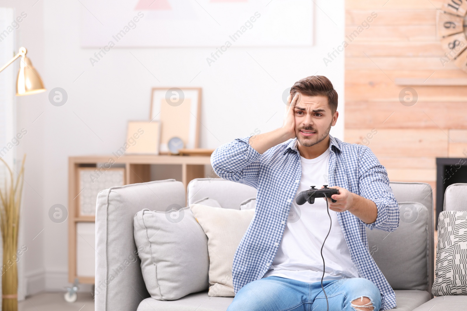 Photo of Emotional young man playing video games at home