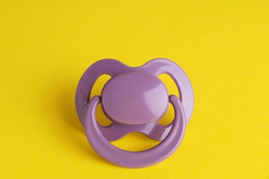 Photo of New cute baby pacifier on yellow background