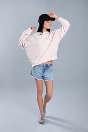 Photo of Full length portrait of young woman in sweater on grey background. Mock up for design