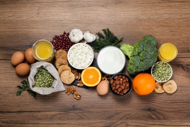 Photo of Set of natural food high in calcium on wooden table, flat lay