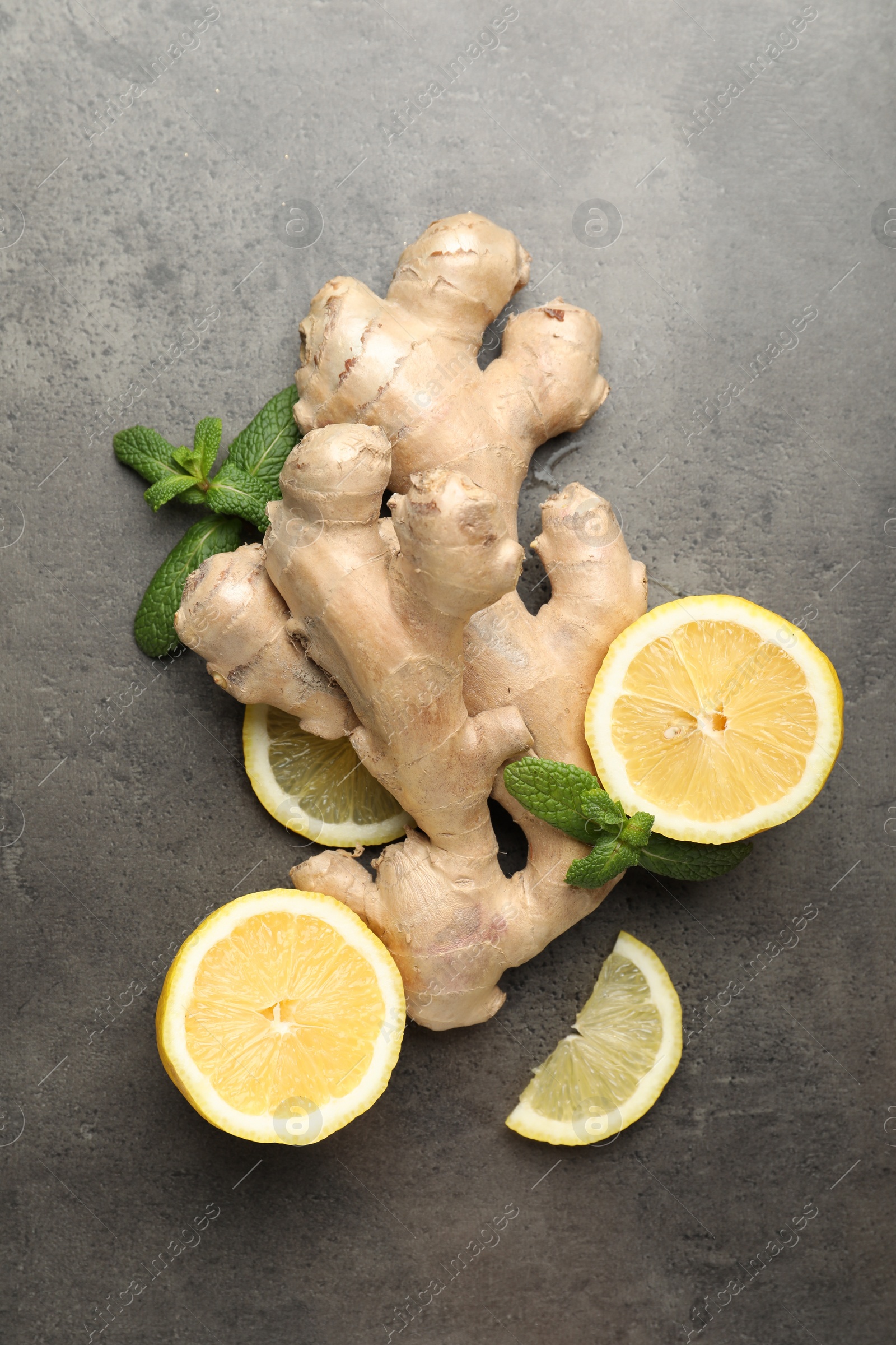 Photo of Fresh lemon, ginger and mint on grey table, flat lay