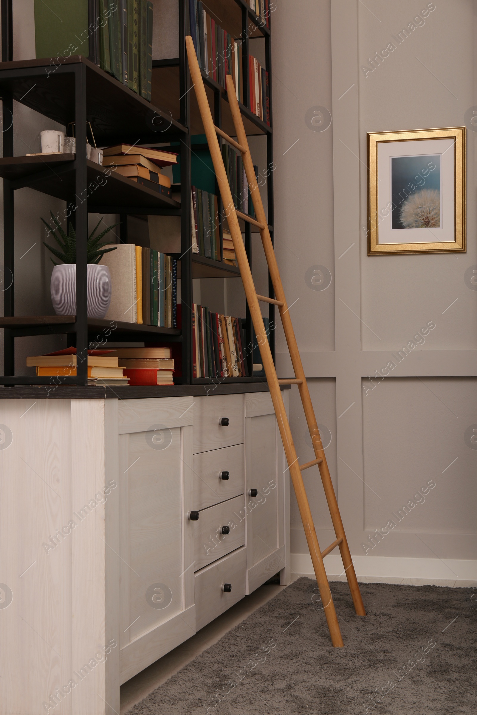 Photo of Home library interior with wooden ladder and collection of books on shelves