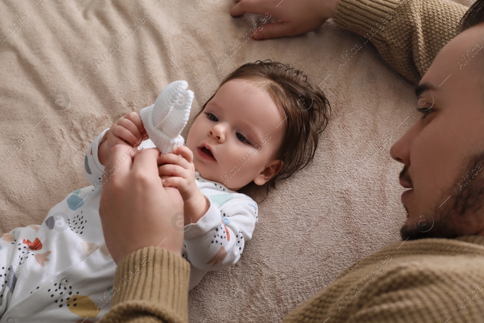 Photo of Father spending time together with his daughter on blanket, top view