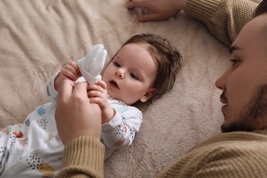 Father spending time together with his daughter on blanket, top view