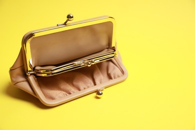 Photo of Stylish beige leather purse on yellow background. Space for text