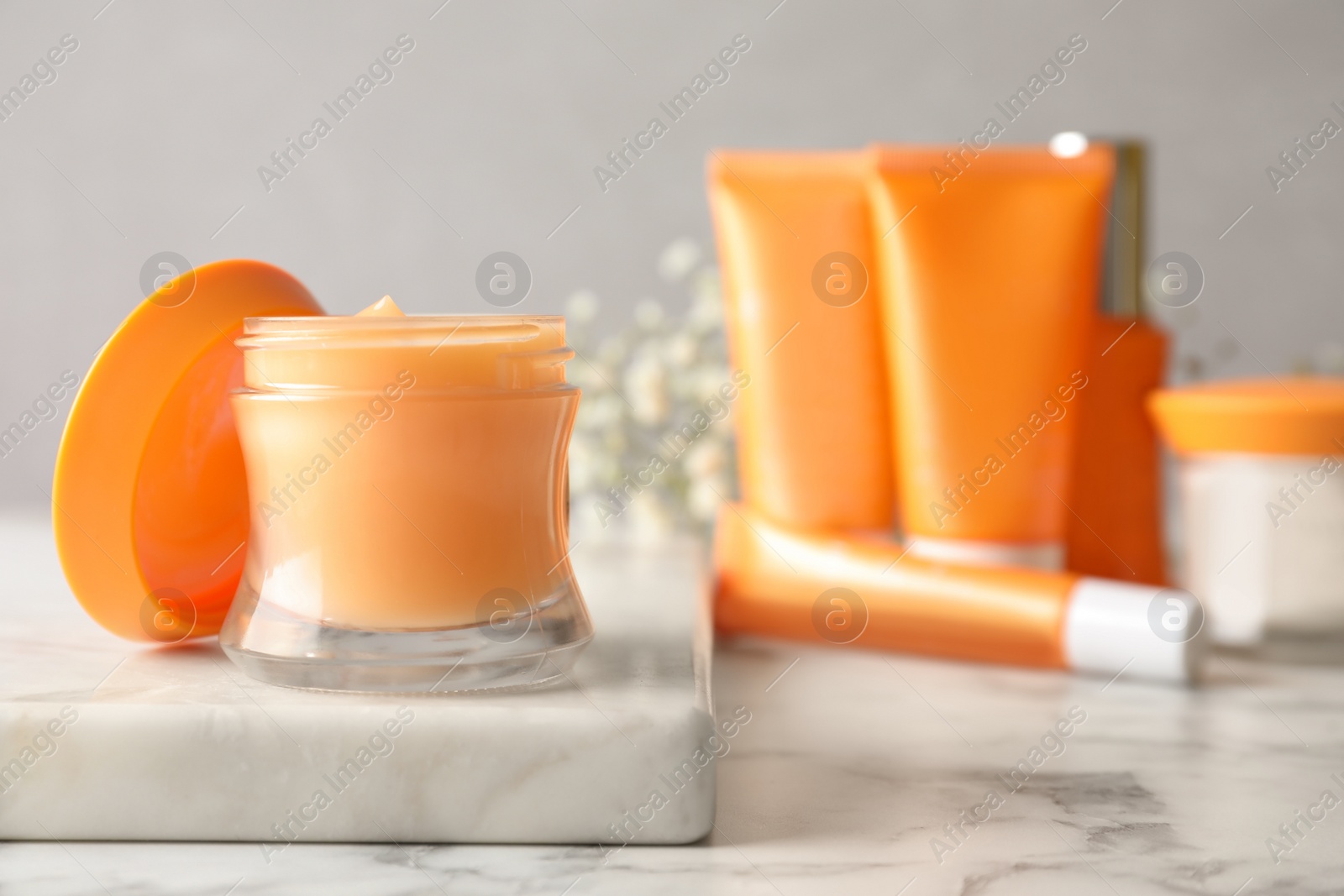 Photo of Luxury cosmetic products on white marble table, closeup. Space for text