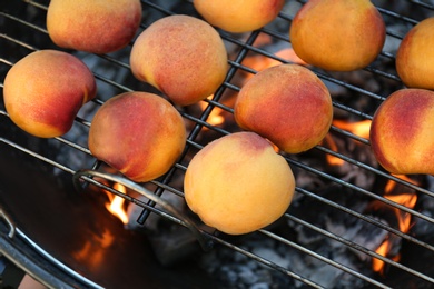 Photo of Modern grill with tasty juicy peaches, closeup