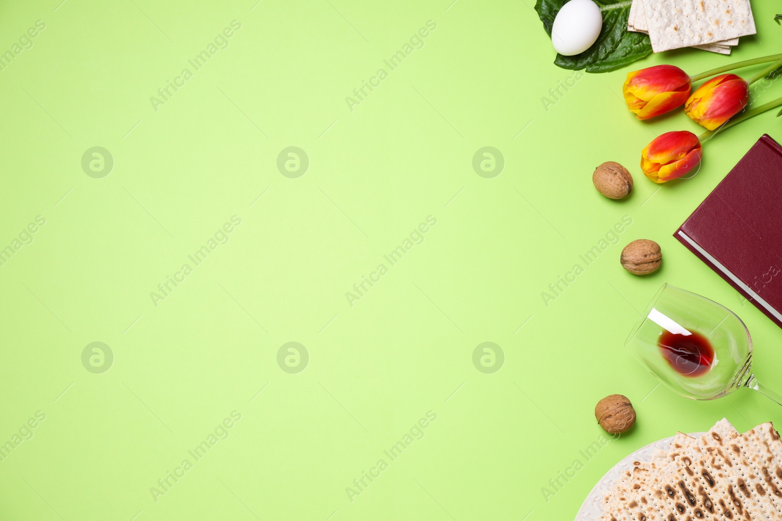 Photo of Flat lay composition with symbolic Pesach (Passover Seder) items on green background, space for text