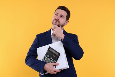 Photo of Thoughtful accountant with calculator and folder on yellow background