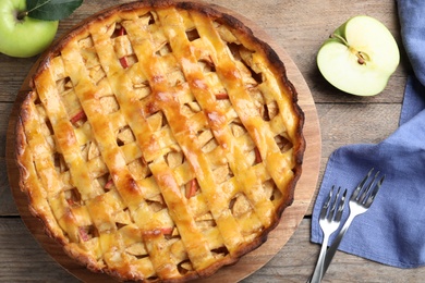 Flat lay composition with fresh traditional apple pie on wooden table