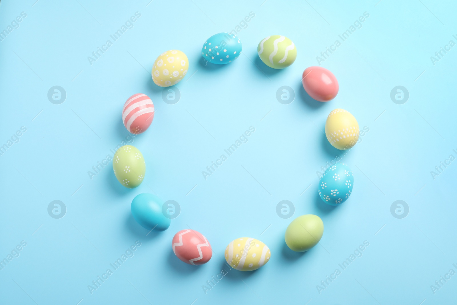 Photo of Flat lay composition of painted Easter eggs on color background, space for text