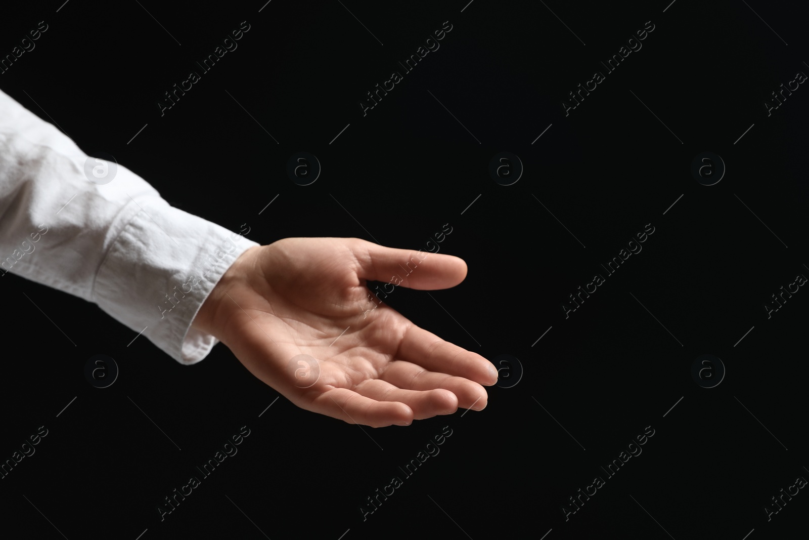 Photo of Woman holding something in hand on black background, closeup. Space for text