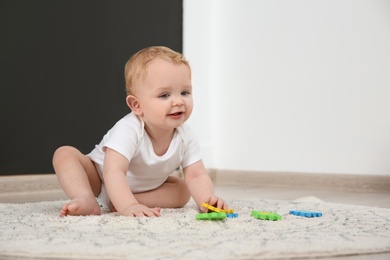 Photo of Cute little baby on rug indoors, space for text. Crawling time