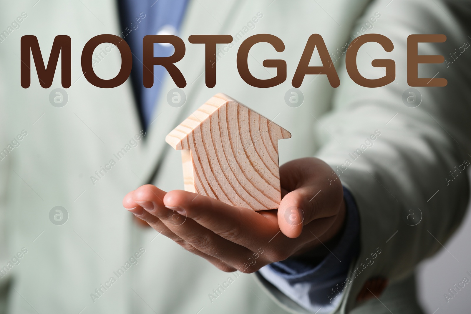 Image of Mortgage concept. Real estate agent with house model , closeup