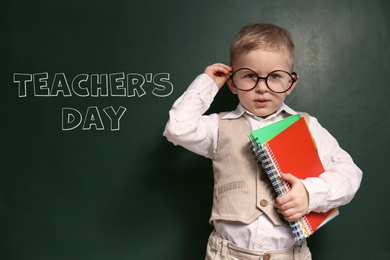 Image of Cute little child wearing glasses near chalkboard with text Teacher's Day