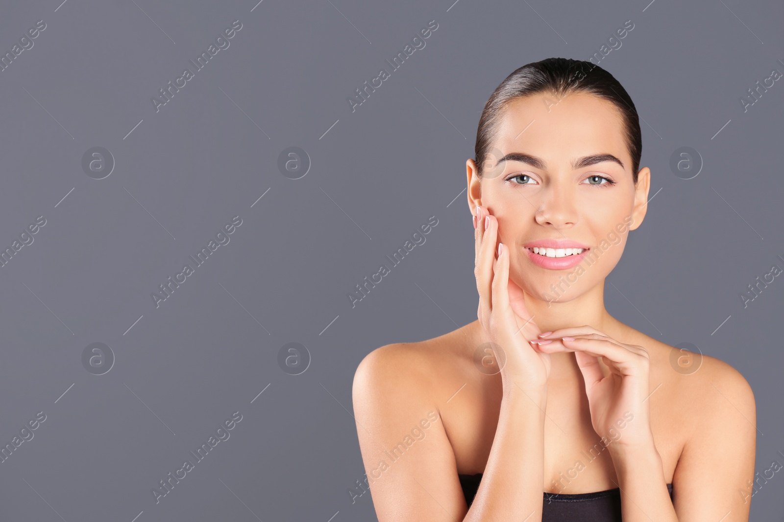 Photo of Portrait of beautiful young woman and space for text on grey background. Cosmetic surgery concept