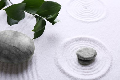 Photo of Zen concept. Stones, leaves and pattern on white sand