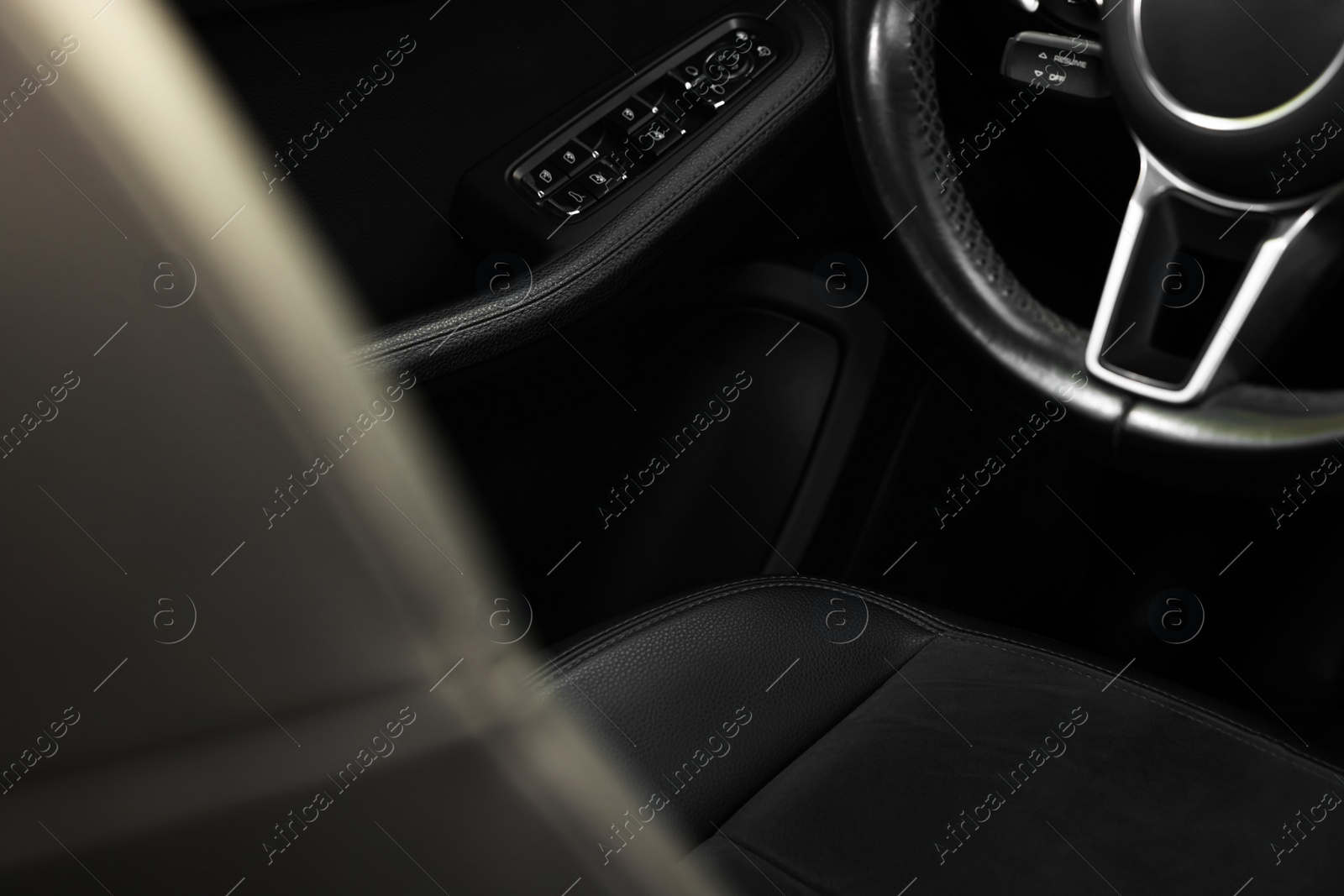 Photo of Steering wheel and leather seat inside of modern car, closeup