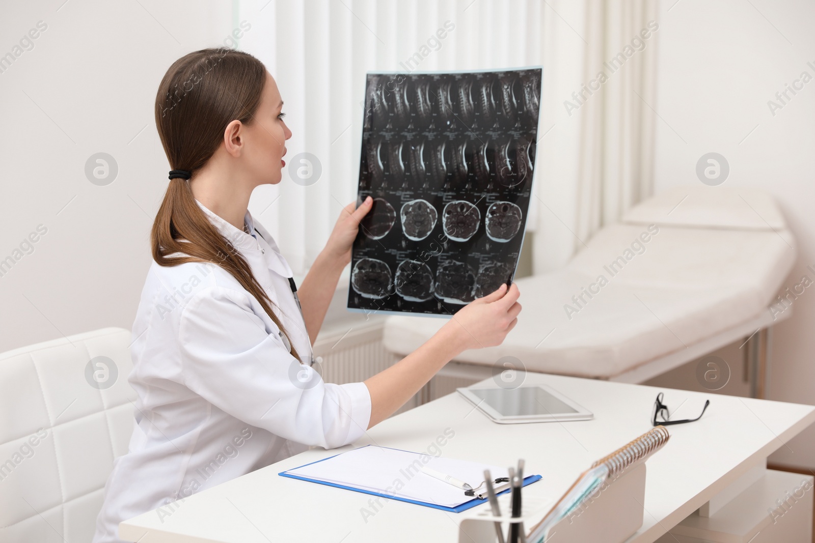 Photo of Orthopedist examining X-ray picture at desk in clinic