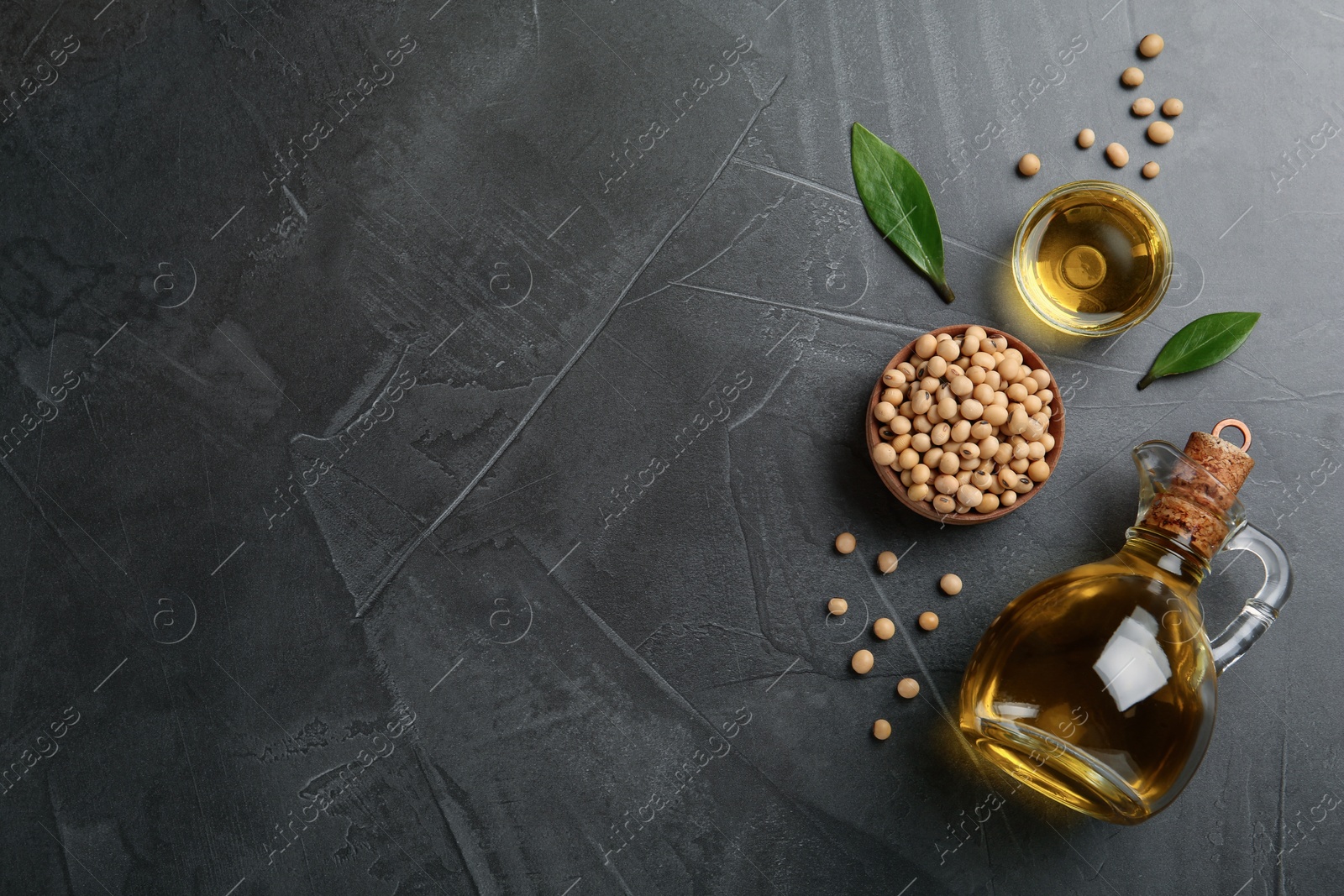 Photo of Flat lay composition with soybean oil on grey table, space for text