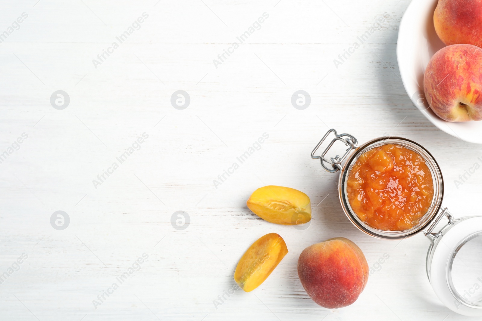 Photo of Flat lay composition with jar of tasty peach jam and fresh fruit on wooden table