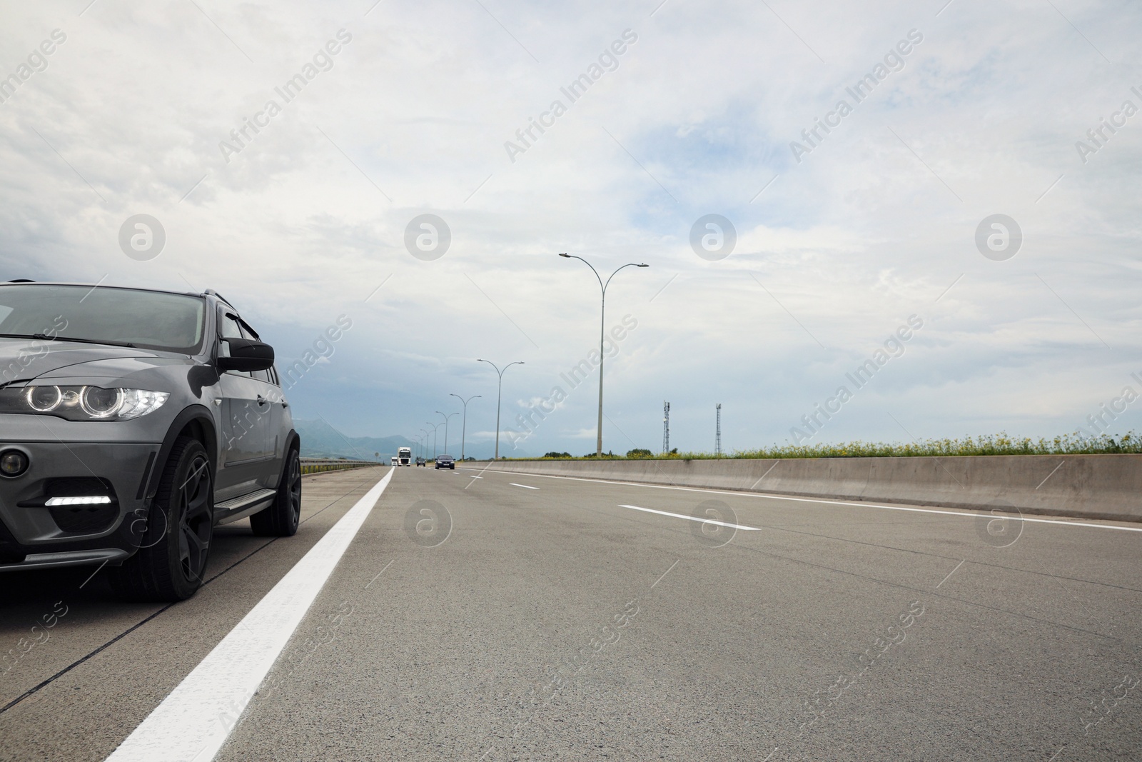 Photo of Grey modern car parked on asphalt road