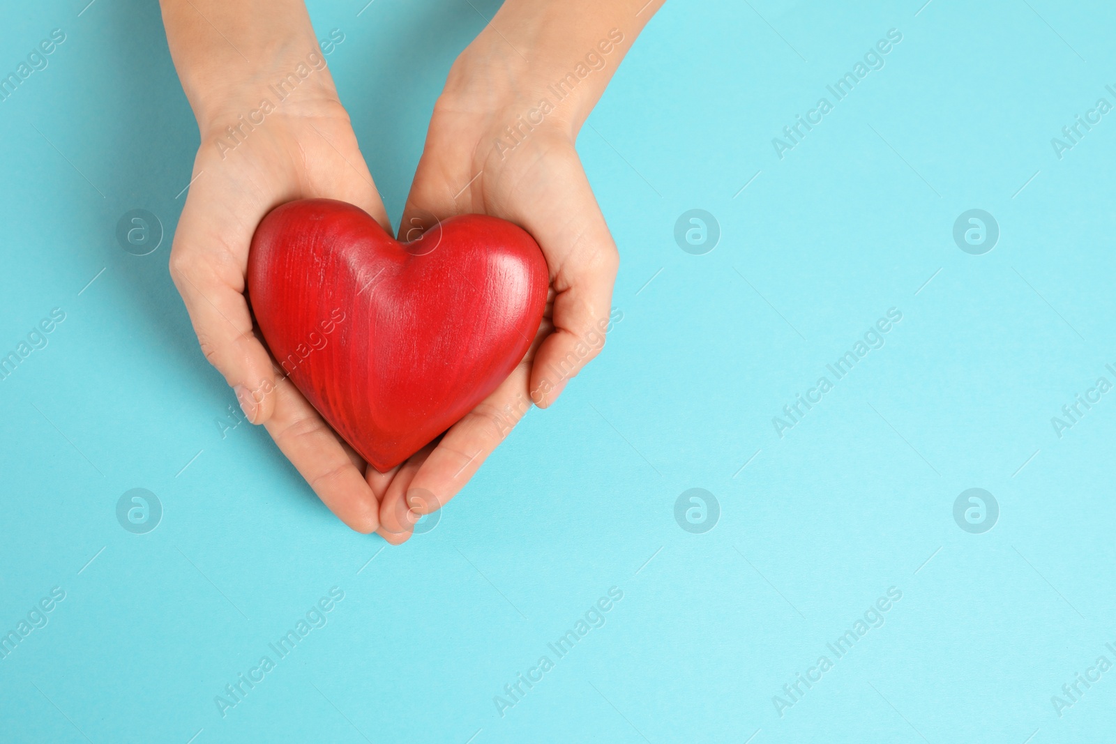 Photo of Woman holding decorative heart on color background, top view with space for text