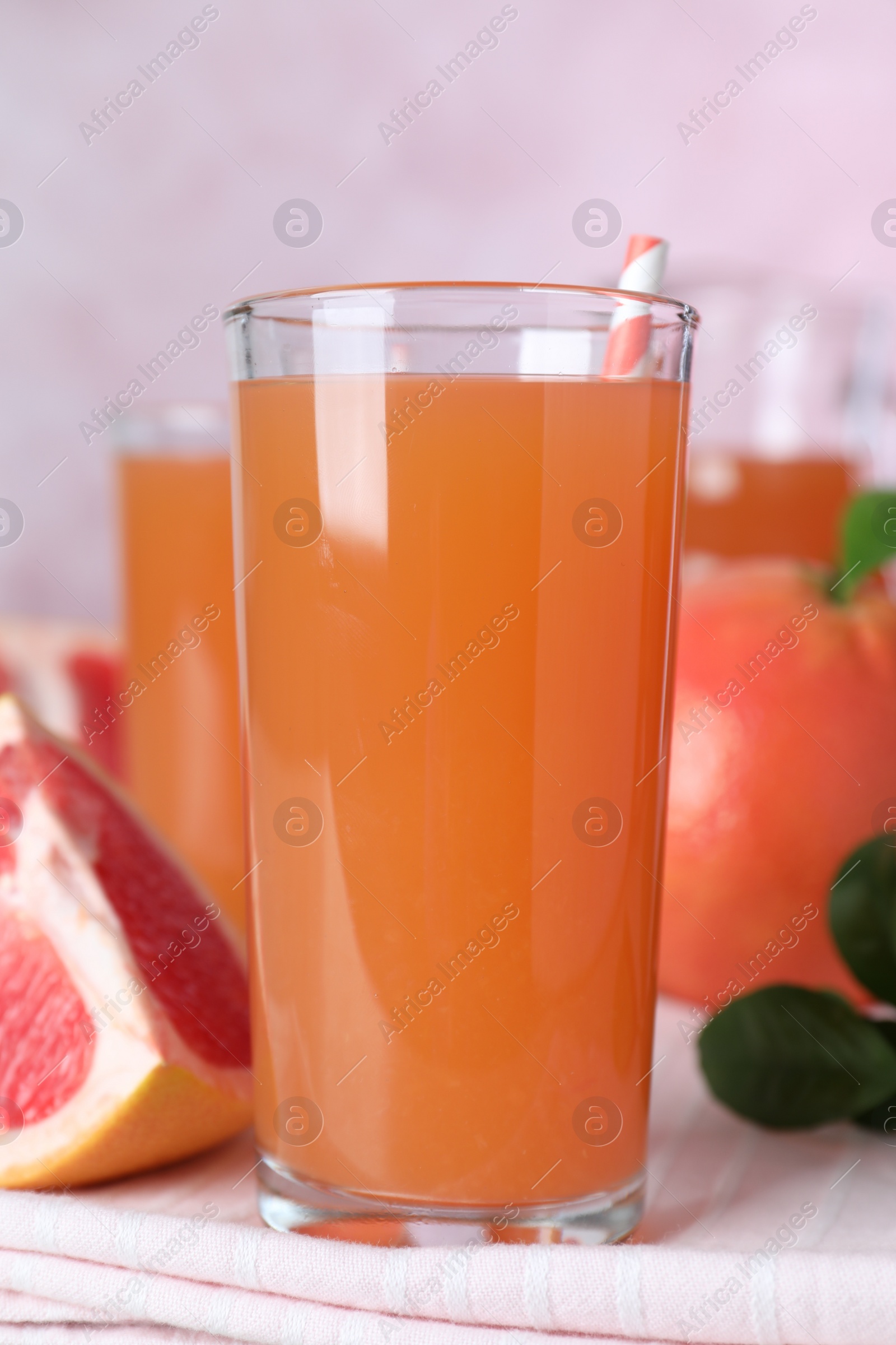 Photo of Tasty freshly made grapefruit juice on towel, closeup