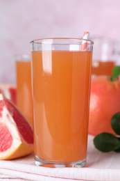 Photo of Tasty freshly made grapefruit juice on towel, closeup