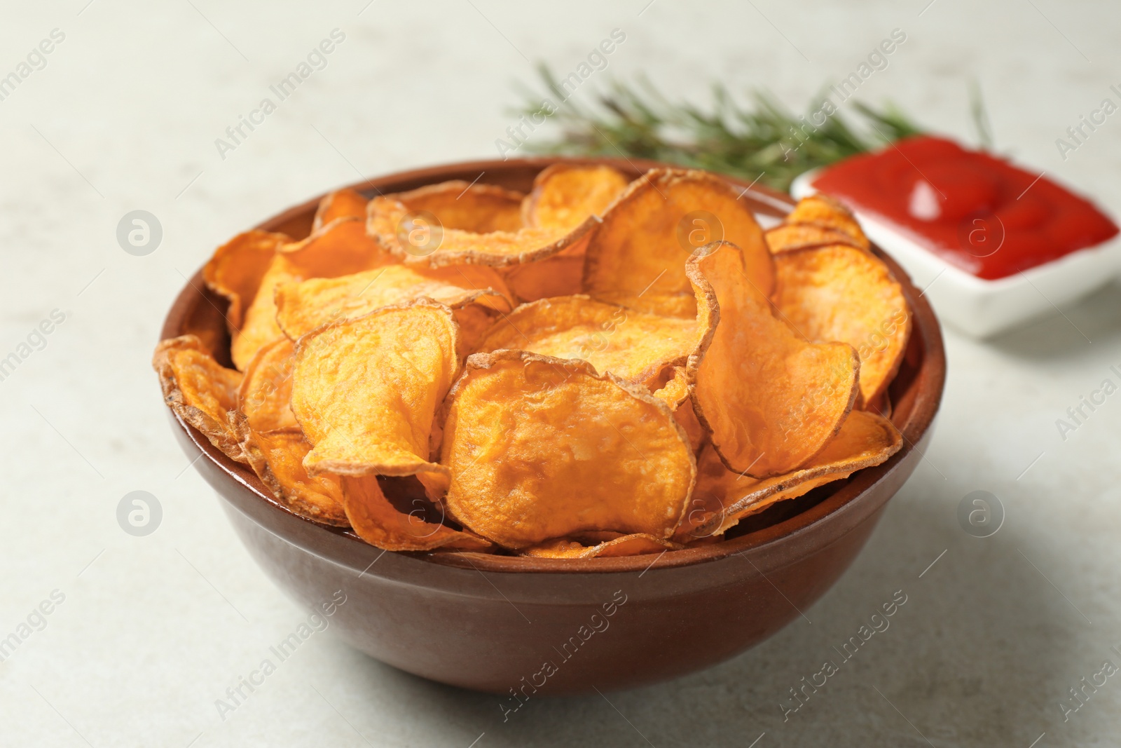 Photo of Delicious sweet potato chips in bowl on table