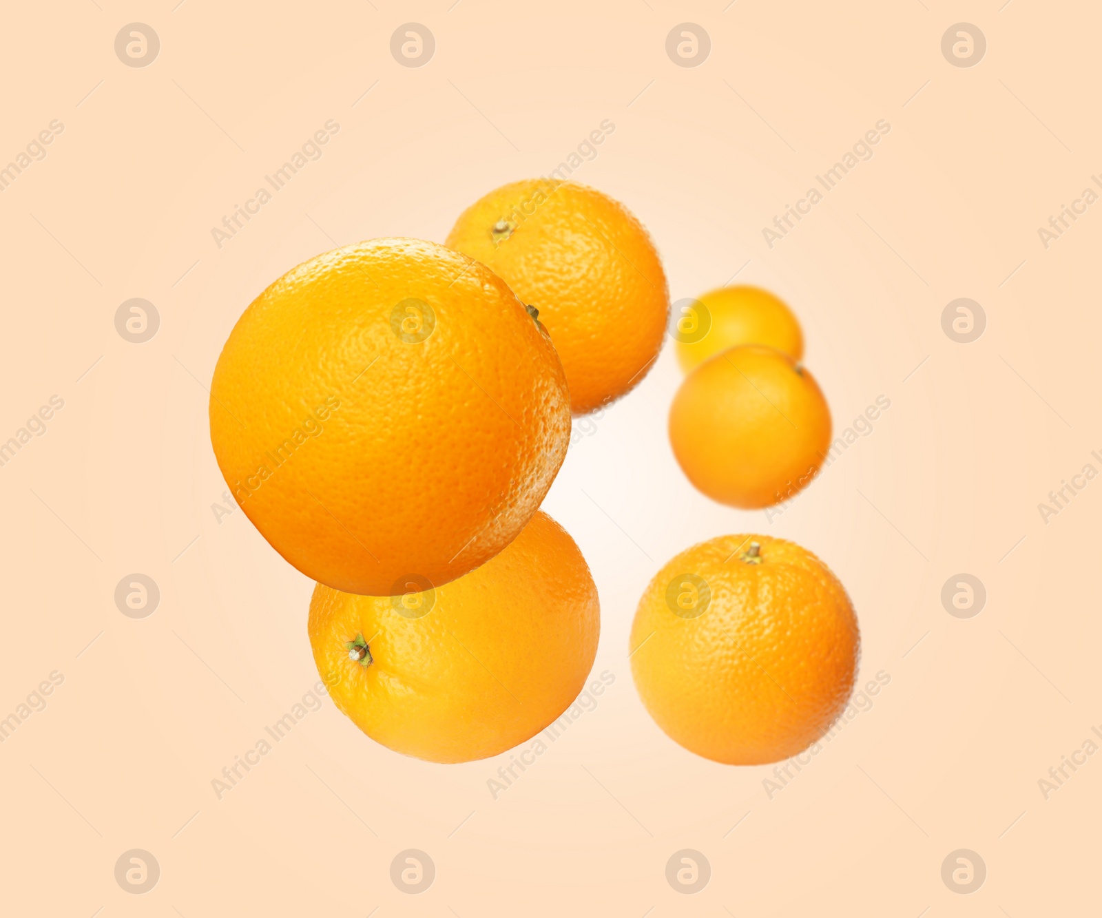 Image of Fresh ripe oranges flying on beige background