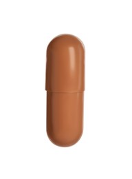 Photo of One brown pill on white background. Medicinal treatment