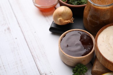 Photo of Fresh marinades and ingredients on white wooden table, space for text