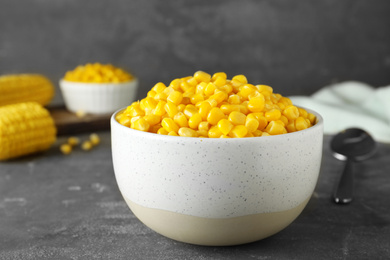 Photo of Delicious canned corn in bowl on grey table