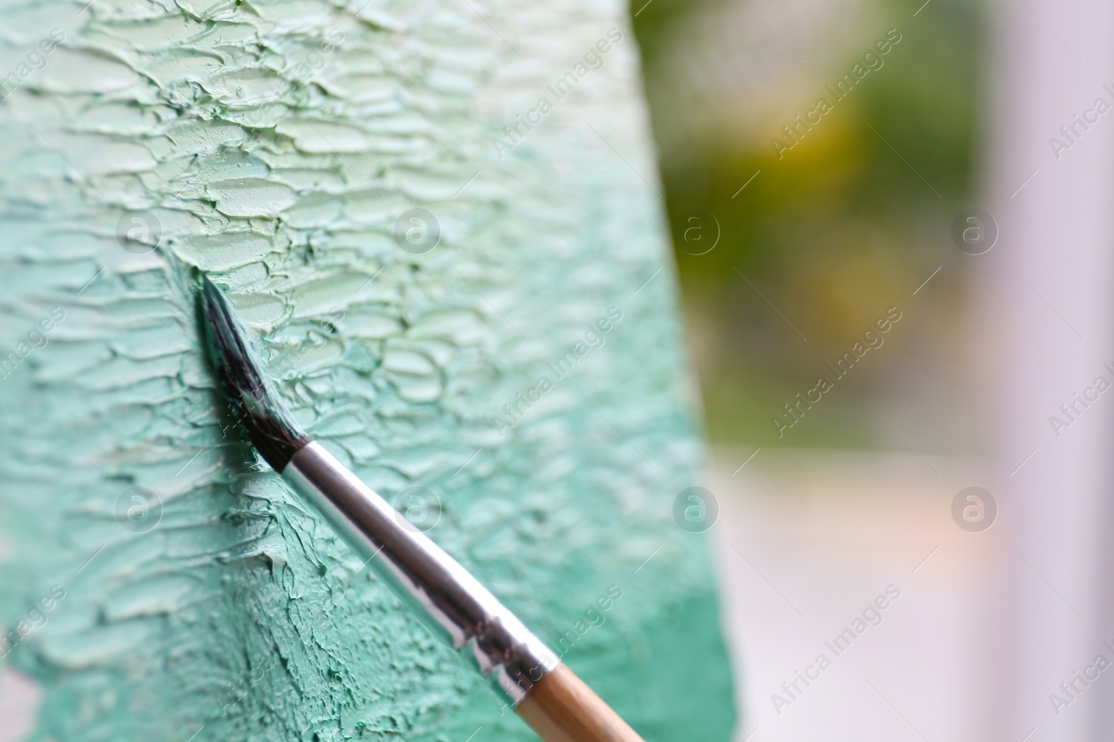 Photo of Artist painting on canvas with brush, closeup