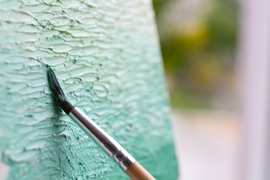 Photo of Artist painting on canvas with brush, closeup