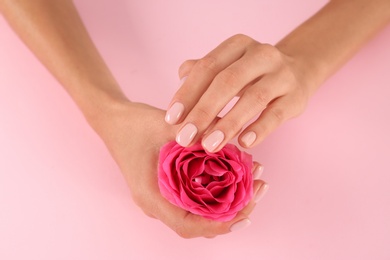 Photo of Closeup view of woman with rose on color background. Spa treatment