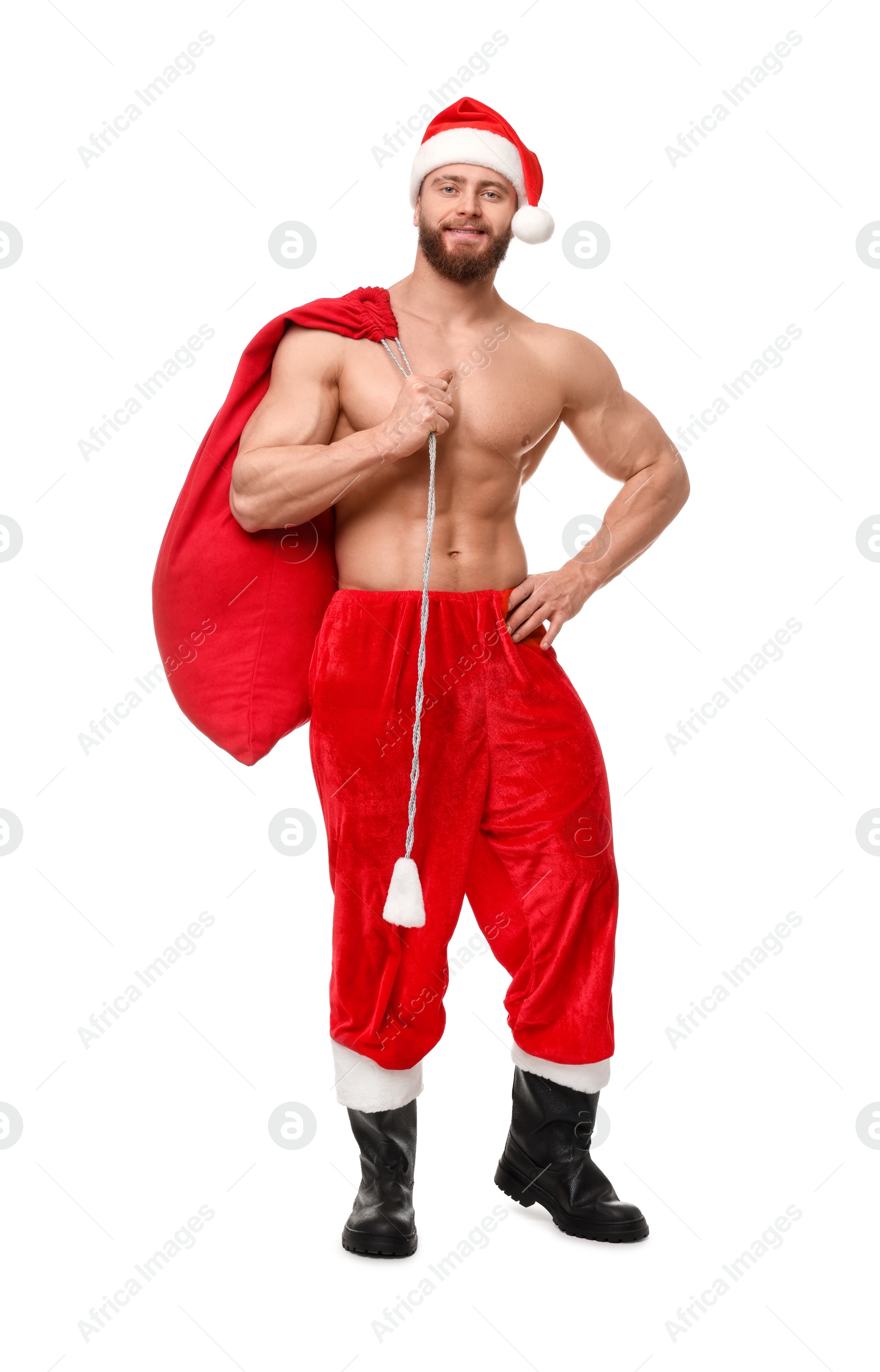 Photo of Muscular young man in Santa hat holding bag with presents on white background
