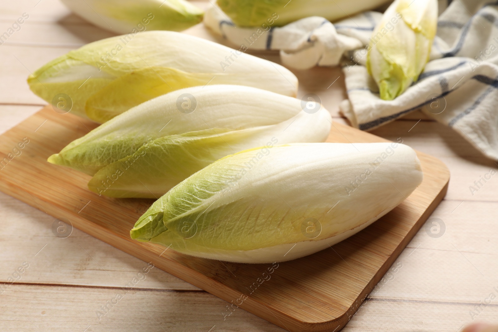 Photo of Raw ripe chicories on wooden table, closeup