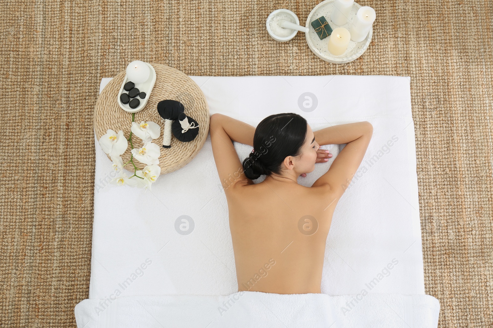 Photo of Young woman relaxing in spa salon, top view