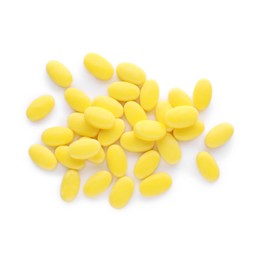 Tasty yellow dragee candies on white background, top view