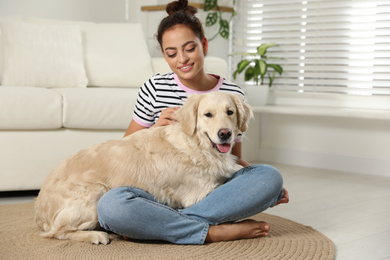 Photo of Young woman and her Golden Retriever at home. Adorable pet