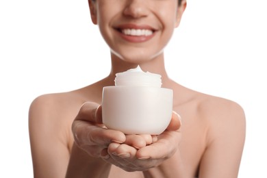 Young woman holding jar of facial cream on white background, closeup