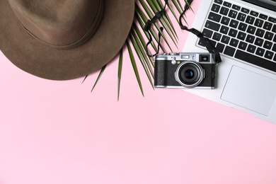 Photo of Flat lay composition with laptop and travel blogger's stuff on pink background. Space for text
