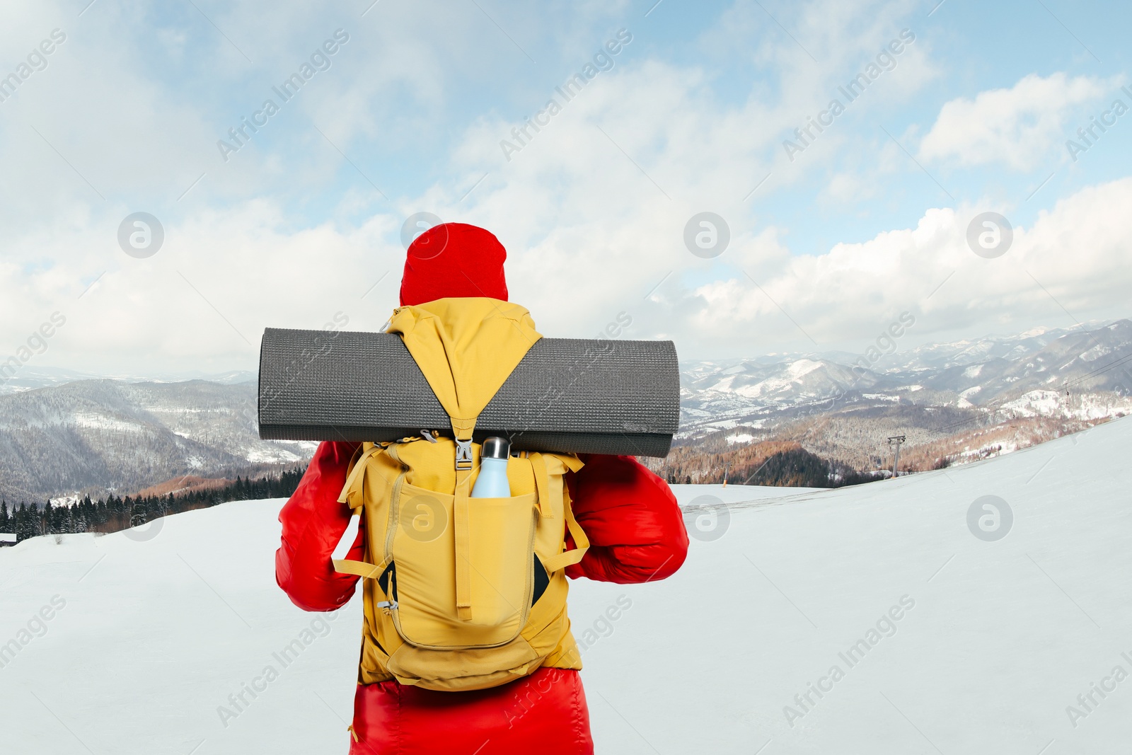 Image of Tourist with backpack in snowy mountains, back view