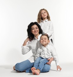 Photo of Little children with their mother on white background